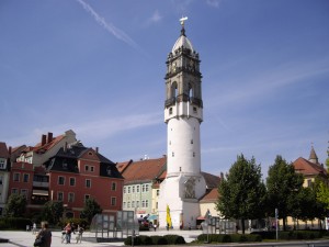 Weißer Turm zwischen Häusern vor blauem Himmel (Reichenturm in Bautzen)