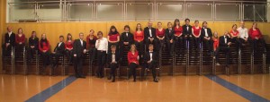 Gruppenfoto des Chors in Konzertkleidung auf einer Reihe von Stuhlstapeln