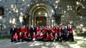 Gruppenfoto des Chores in Konzertkleidung vor einem Kirchenportal