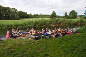 Gruppe von Kanadiern und Kajaks macht Pause an einer Anlegestelle